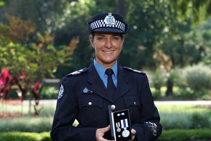 A police officer holding a medal in a case