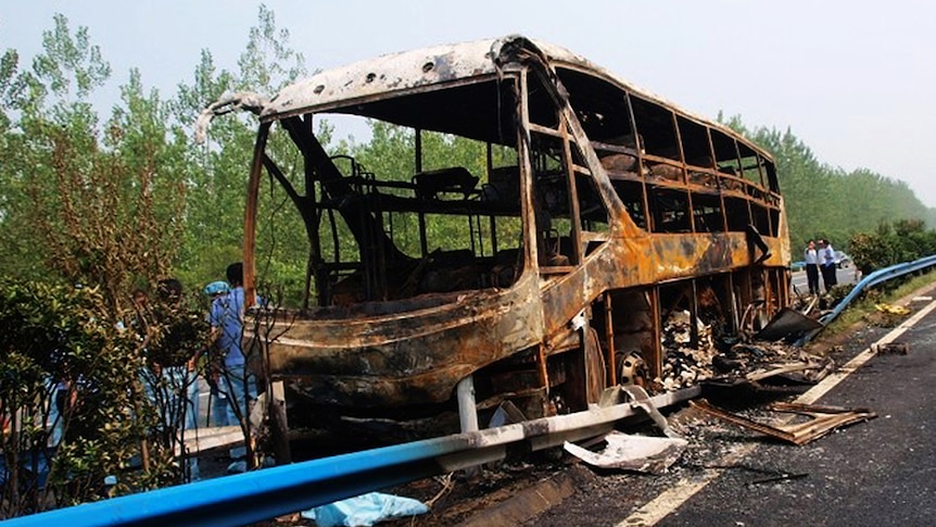 Chinese police investigate the burnt wreckage of a double-decker coach that was carrying hazardous goods and caught fire.