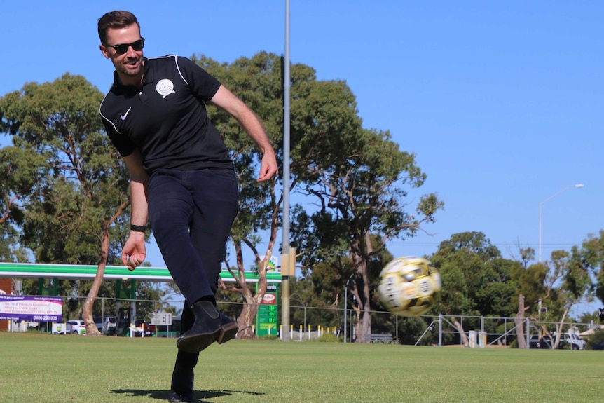 A man plays soccer in a park