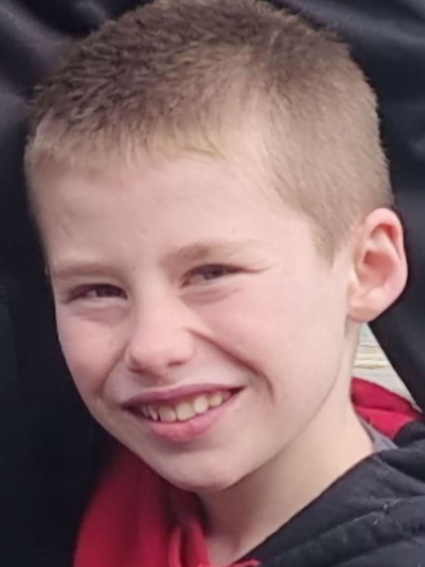 a boy smiles at the camera.
