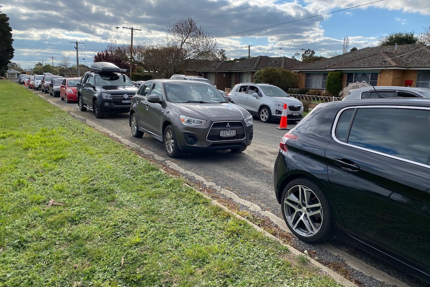 Line of vehicles with people waiting inside