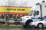 Police vehicles sit outside a Waffle House restaurant.