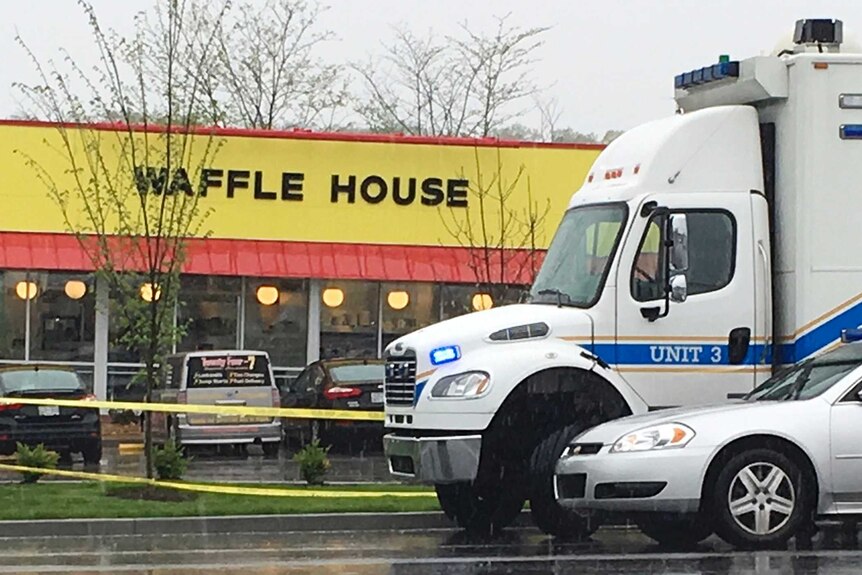 Police vehicles sit outside a Waffle House restaurant.