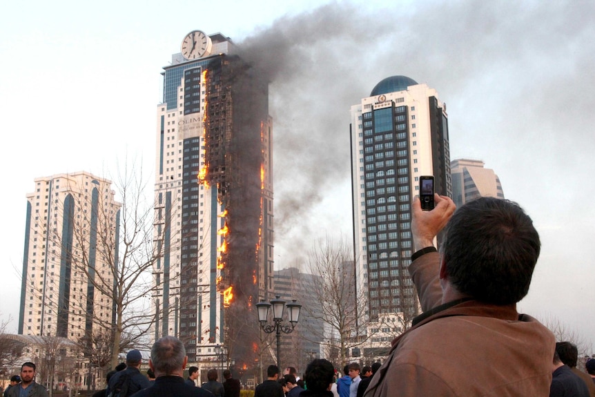 Man photographs burning skyscraper in Grozny.