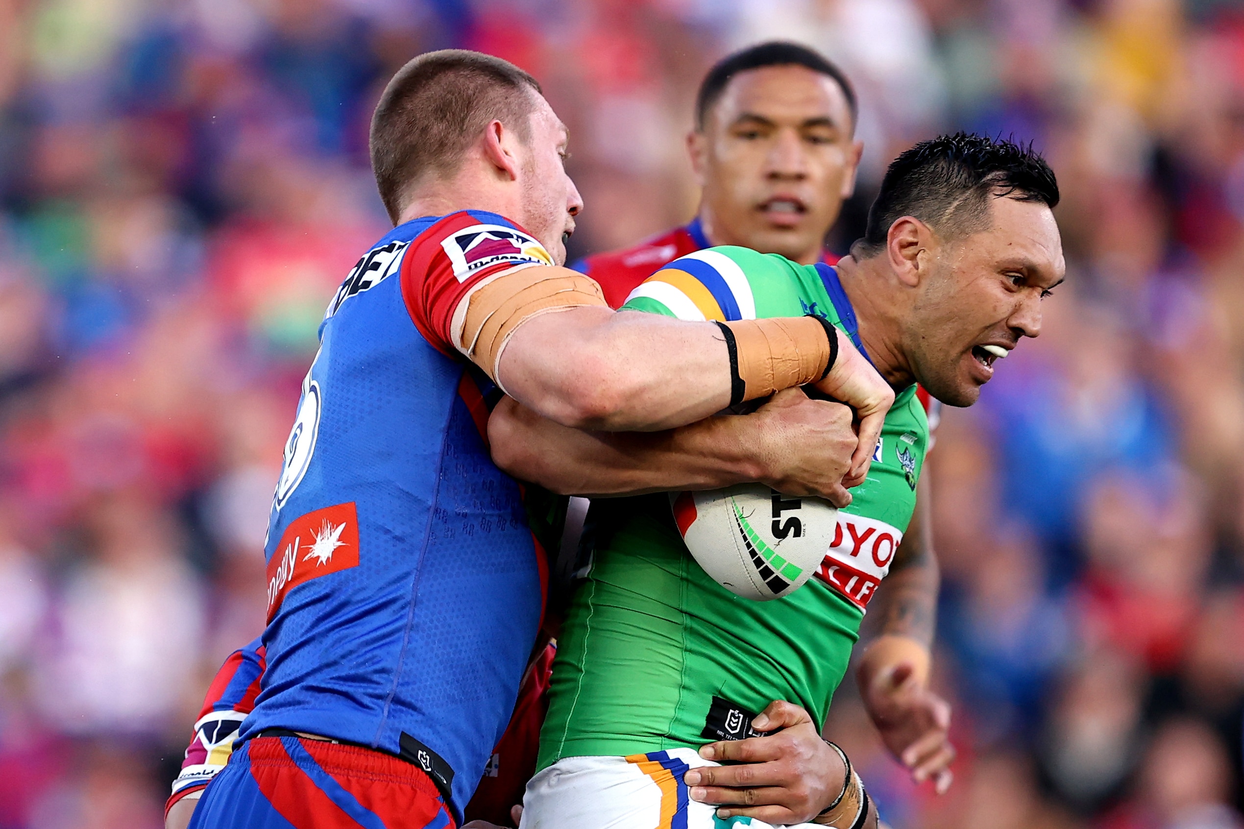 A man tries to break a tackle during a rugby league match