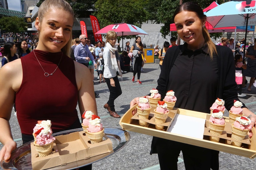 Two people holding ice-cream cones.