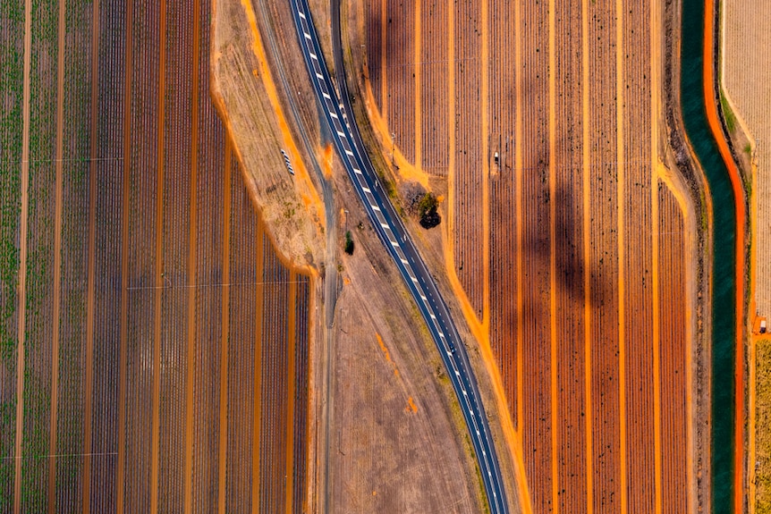 Red farmland and a country road seen from the air 