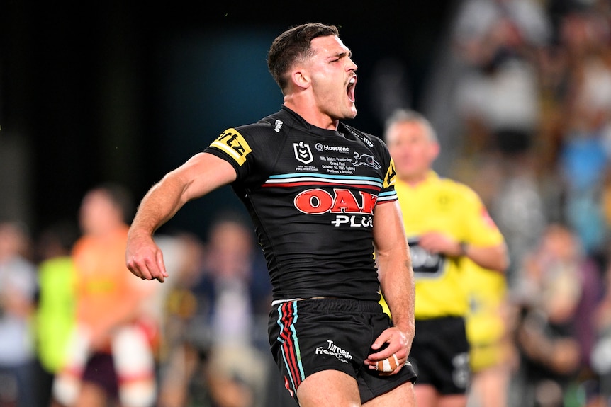 A man in black rugby league kit celebrates.