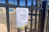 A sign on a gate that reads "School closed today".