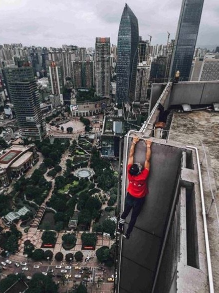Chinese "rooftopper" Wu Yongning hanging off a building.