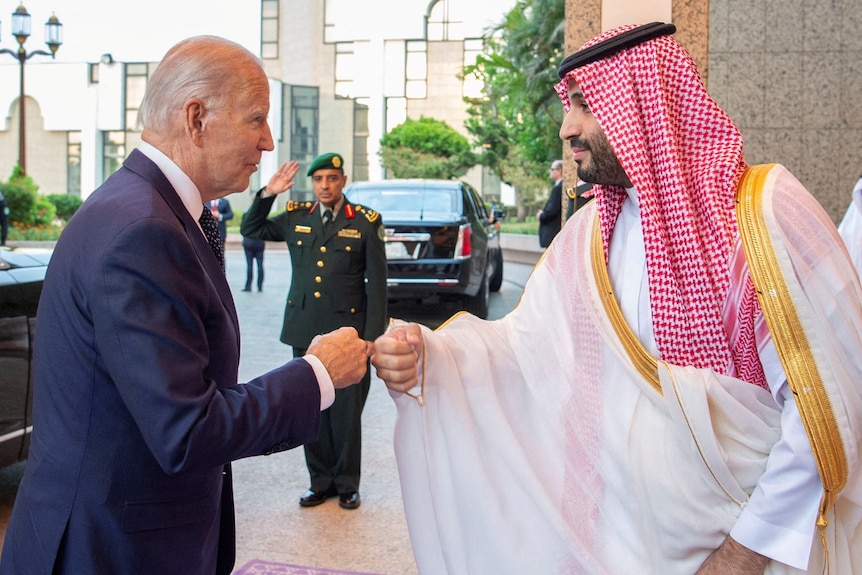 Two men fist bump.