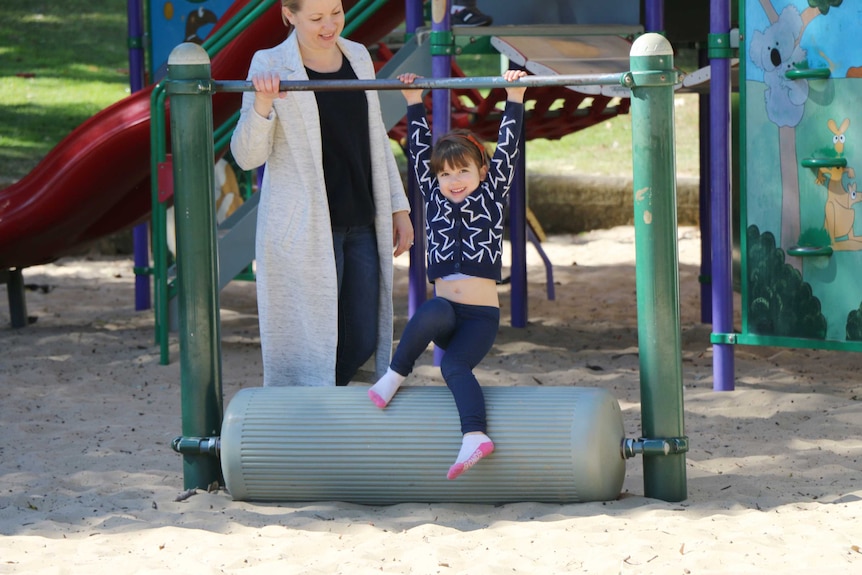 Four-year-old Sadie swings on play equipment at a Sydney playground
