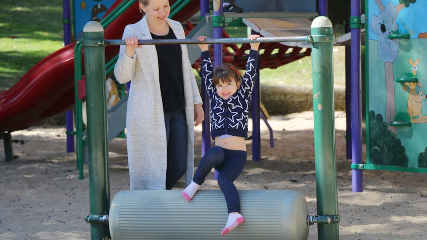 Four-year-old Sadie swings on play equipment at a Sydney playground
