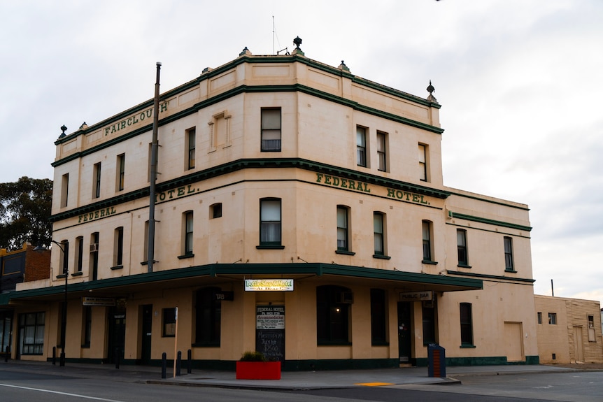 An old, three-storey pub sits on a corner in an outback town.