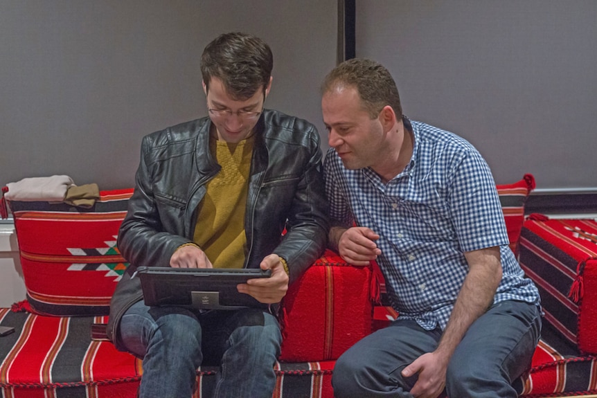 Amina's sons Majd and Rasheed Rustom look through family photos from Syria.