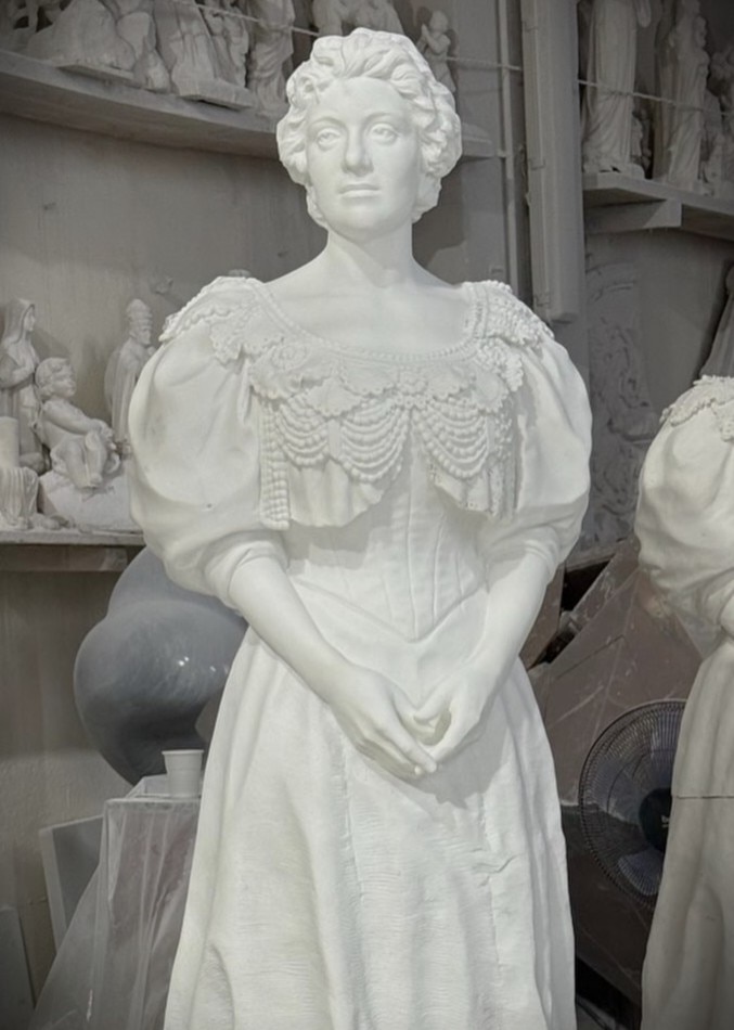 Una escultura de una mujer con ropa contemporánea.