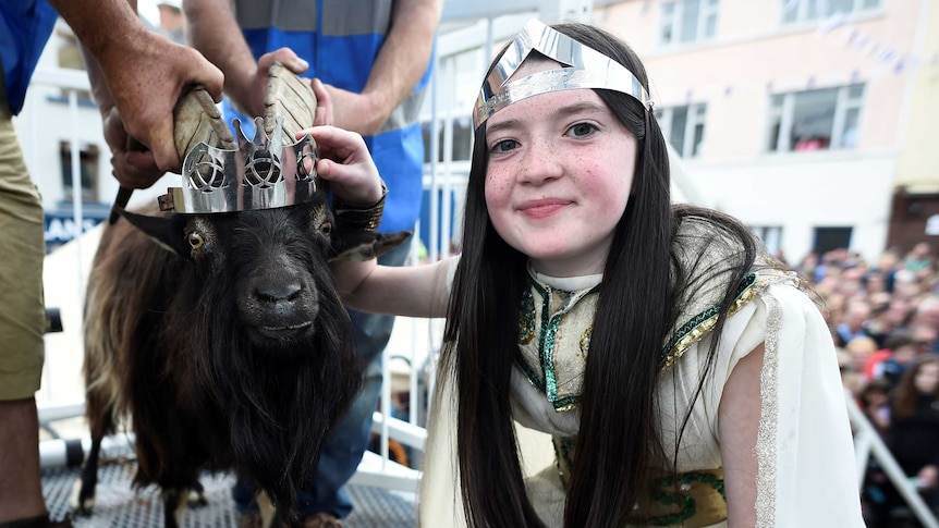 12-year-old Puck Queen Caitlin Horgan poses with a wild goat wearing a crown.