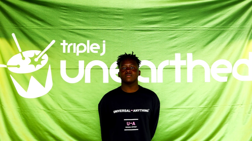 Arno Faraji with the triple j Unearthed Banner