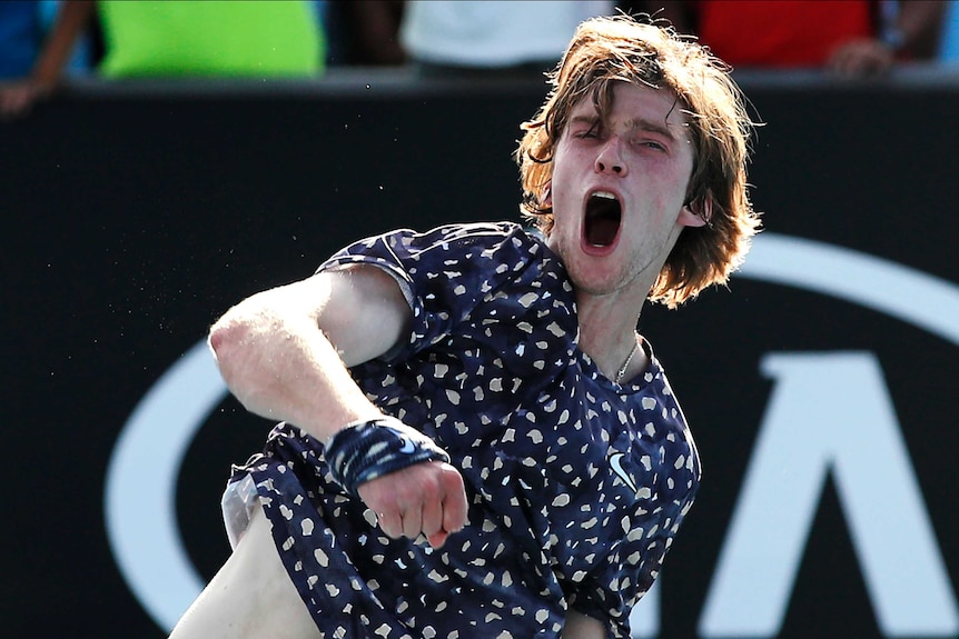 A tennis player roars in triumph and punches the air after winning an Australian Open match.