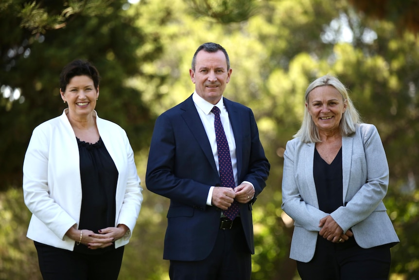Mark McGowan stands in the middle of Jackie Jarvis and Sabine Winton as they smile for a photo