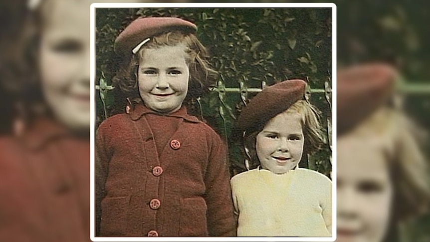 Rose Collins wears a white shirt and red hat standing next to her older sister dressed in a red shirt and cardigan with red hat