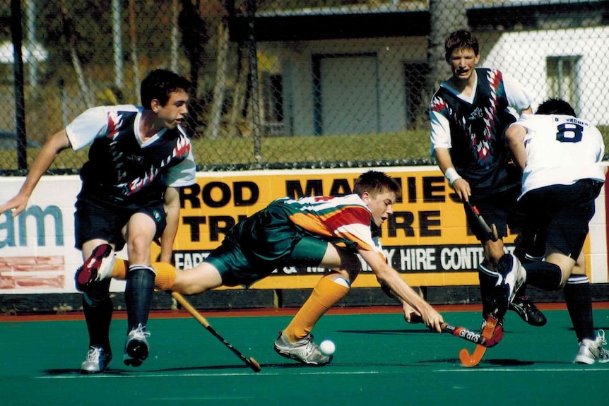 Boys playing hockey on artificial grass