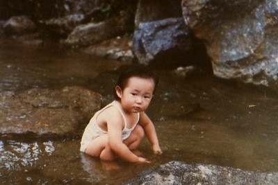 A young girl bends down in a rockpool