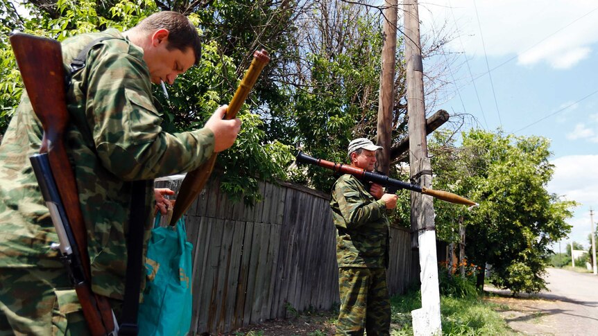 Armed pro-Russian separatists stand guard in Siversk