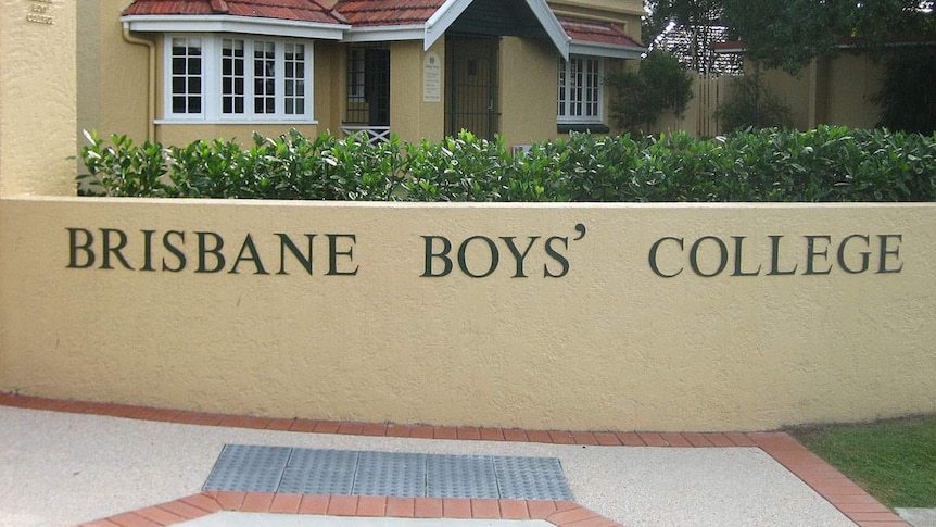 The walled front entrance to Brisbane Boys' College with a two-storey building visible behind it