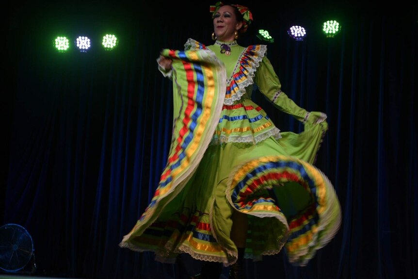 A dancer in a bright dress performs on the Folklorica stage at the 2016 Woodford Festival.