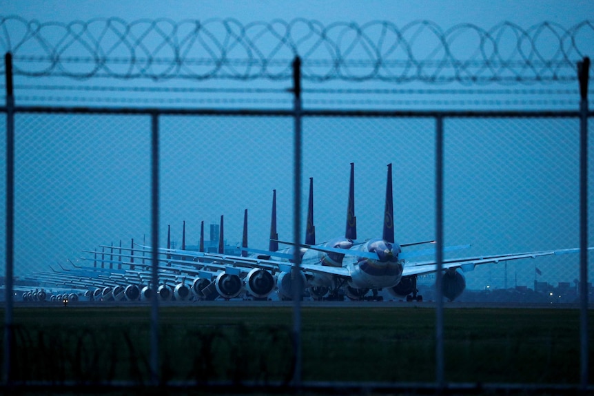 Thai Airways idle airplanes are seen parked on the tarmac.