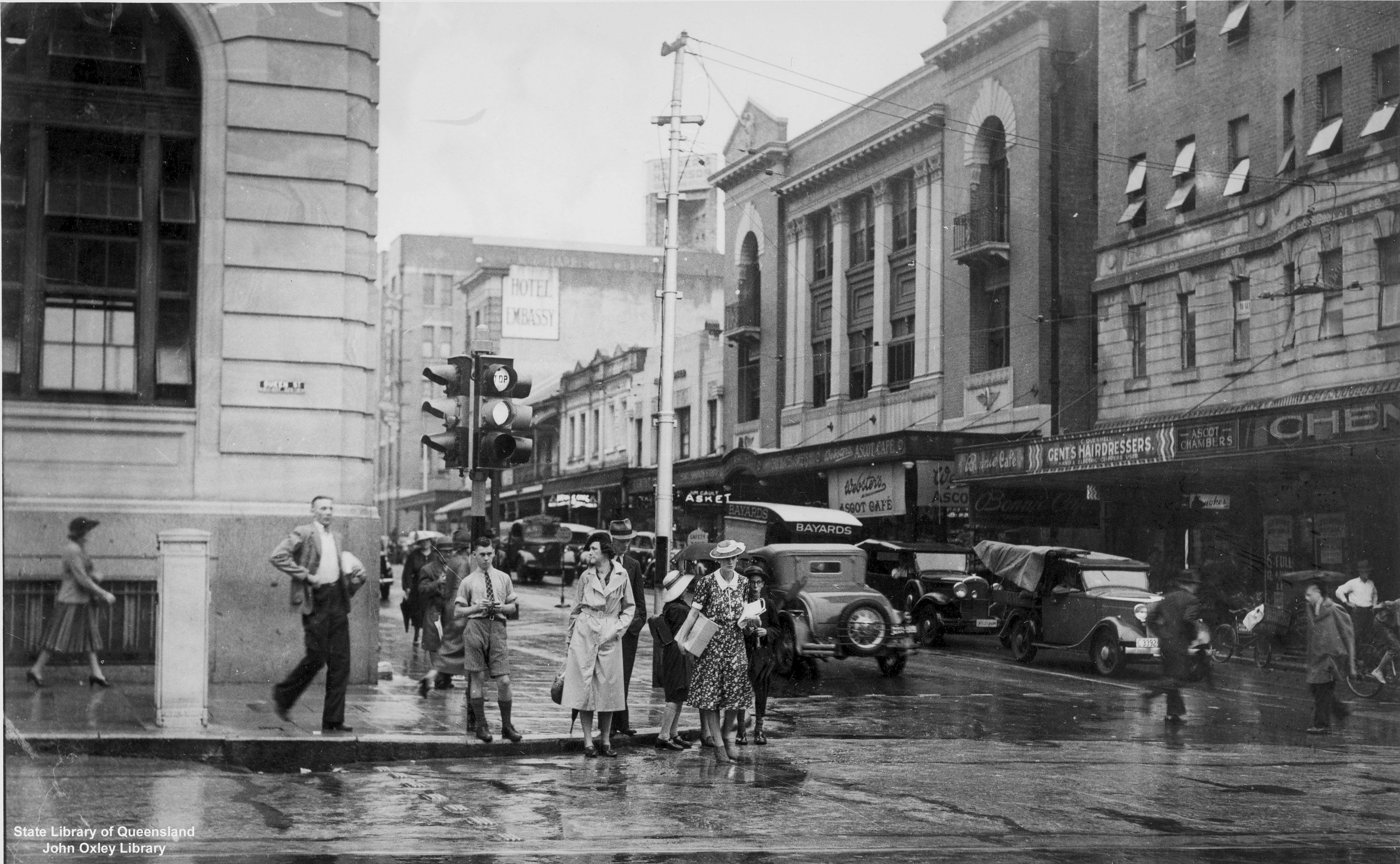 A black and white photo of pedestrians and cars in Brisbane's CBD in 1940.