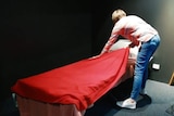 A woman setting up a bed at a homeless shelter in Wangaratta