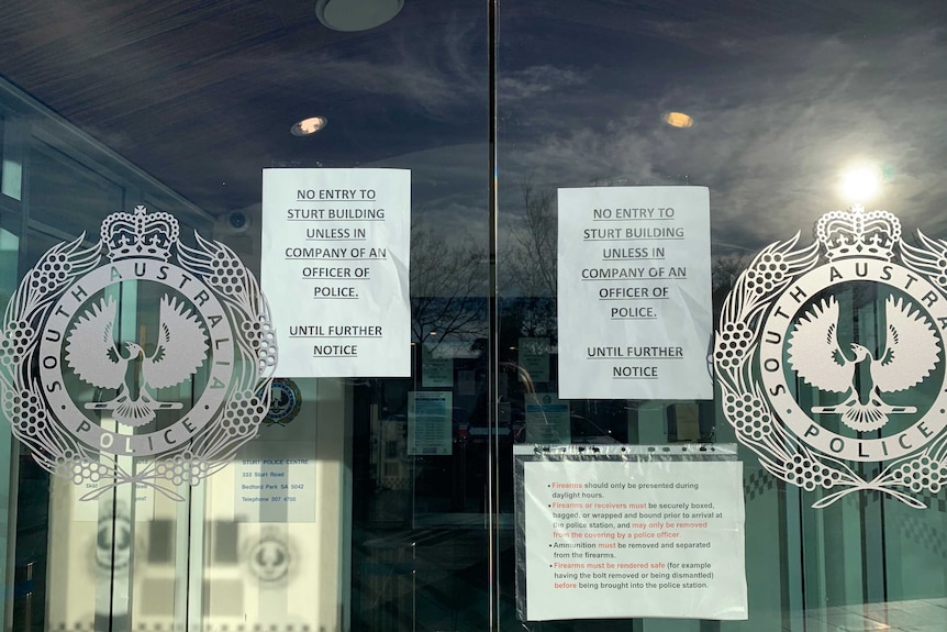 Signs on the glass doors to the Sturt Police Station prohibiting access.