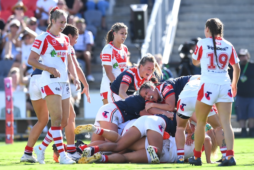 A group of NRLW players celebrate a try 