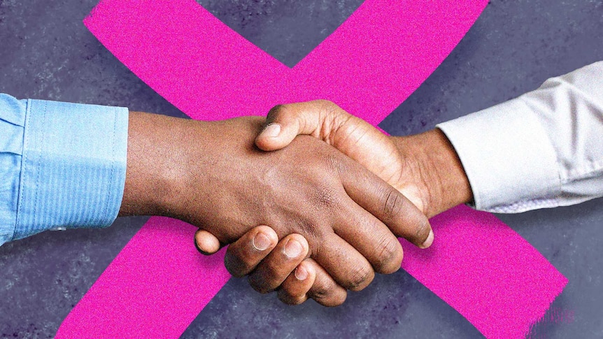 Two people shake hands in front of a big X.