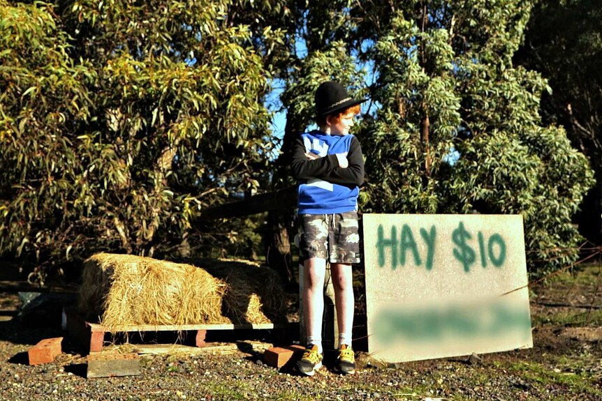Matthew Nairn selling hay bales in front of his house.