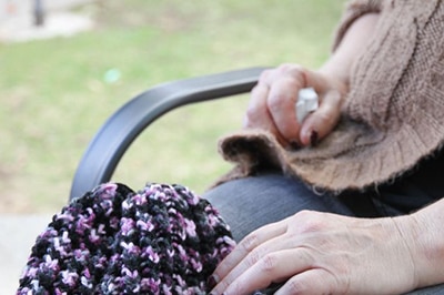 Woman's lap with knitted hat.