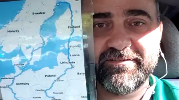 A man with a beard holding a laminated map of Europe