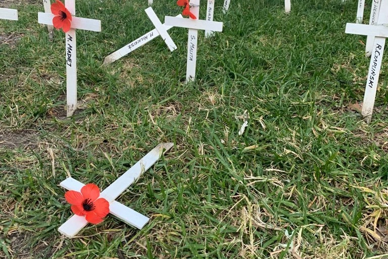 Small crosses fallen over on grass