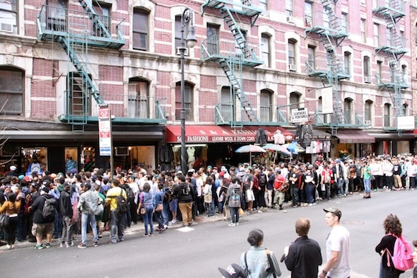 一群人在一家店铺门前排起长队。