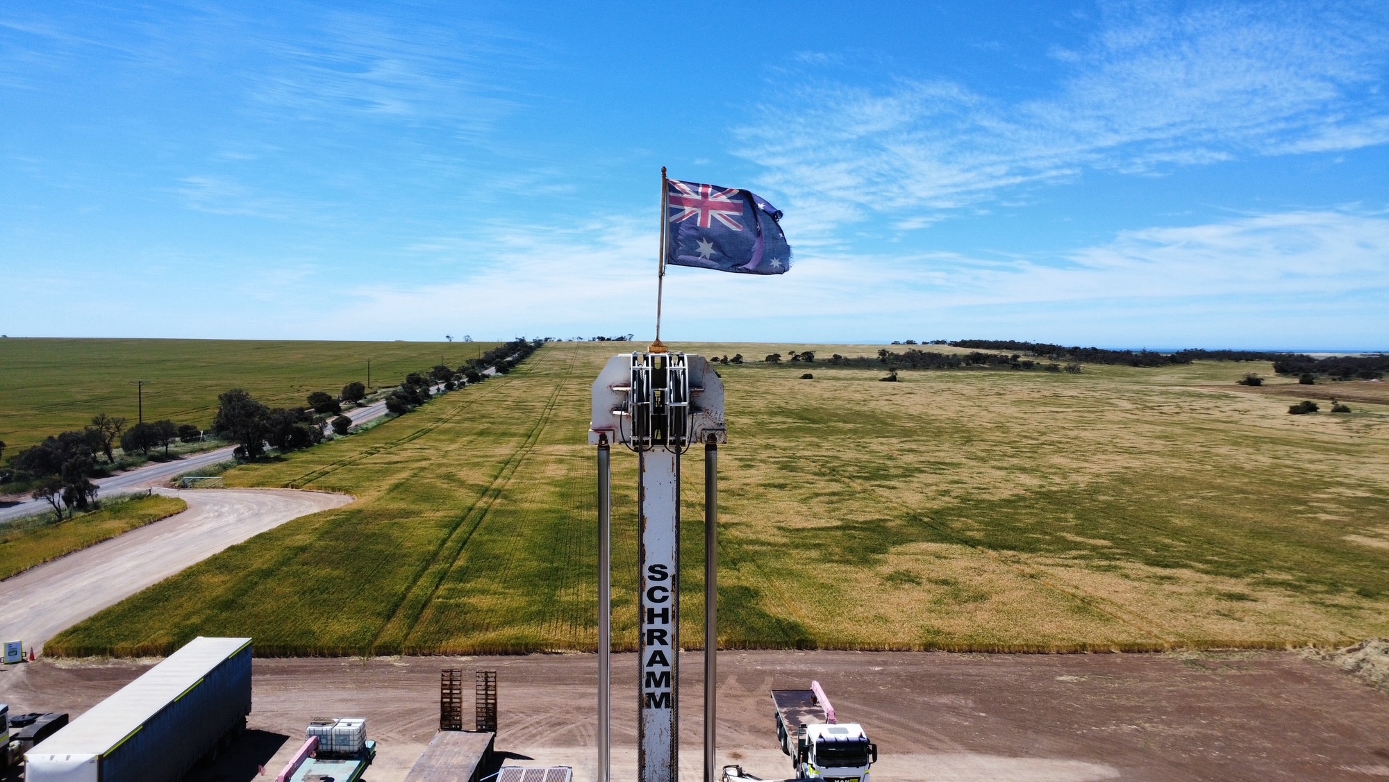 Una bandera australiana en una plataforma petrolera con campos de hierba detrás