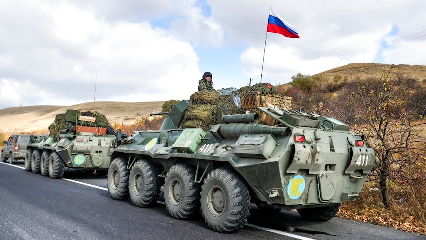 Vedete due grandi veicoli militari russi parcheggiati sul lato di una strada di campagna in una giornata nuvolosa.
