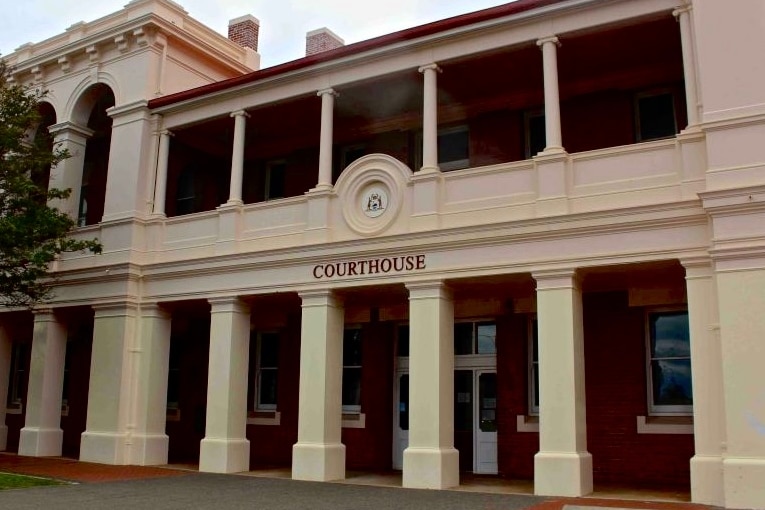 photo of exterior facade of historic Geraldton Courthouse with columns and red brick.