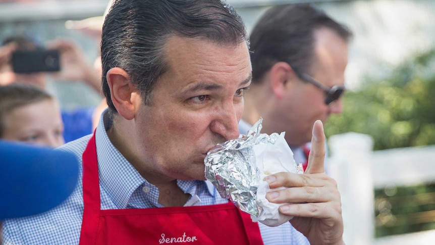 Republican presidential candidate Ted Cruz eats a pork chop at the Iowa State Fair