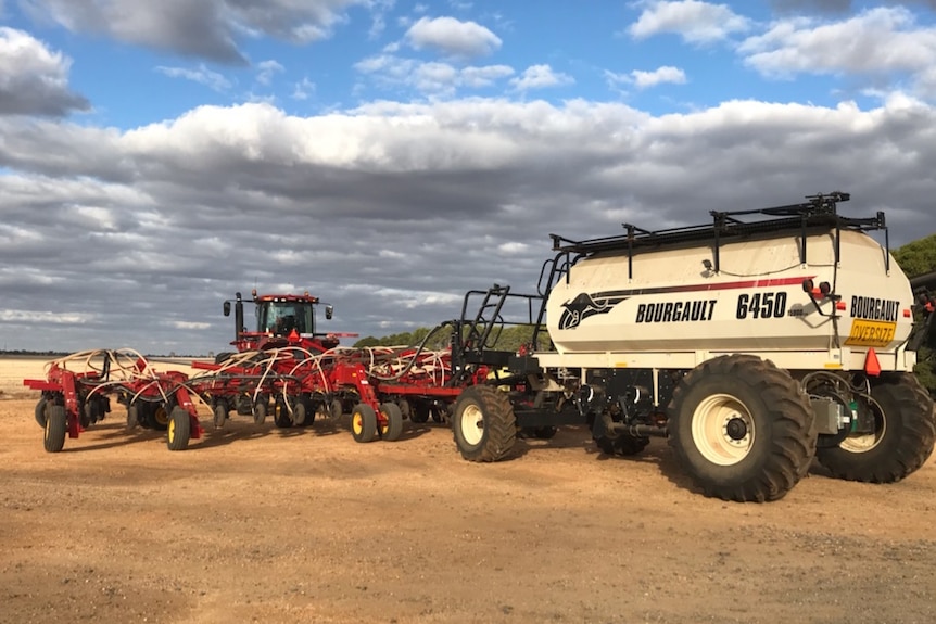 Farming machinery sits in a field