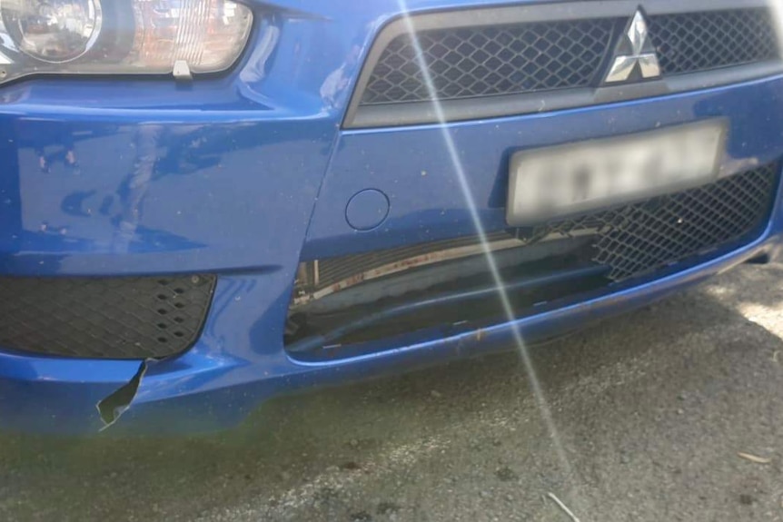 The front grille and bumper of a car, which are cracked and broken.