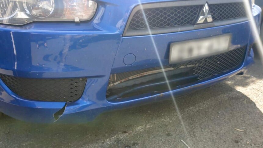 The front grille and bumper of a car, which are cracked and broken.