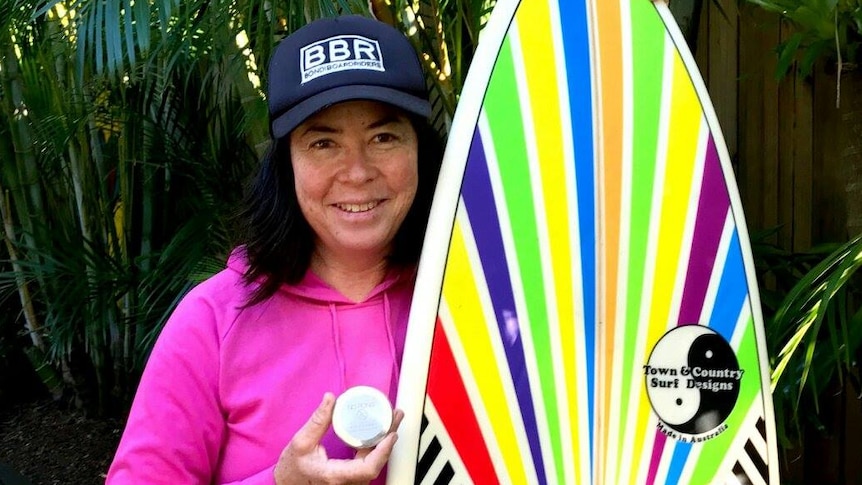 Pauline Menczer with a medal and surfboard