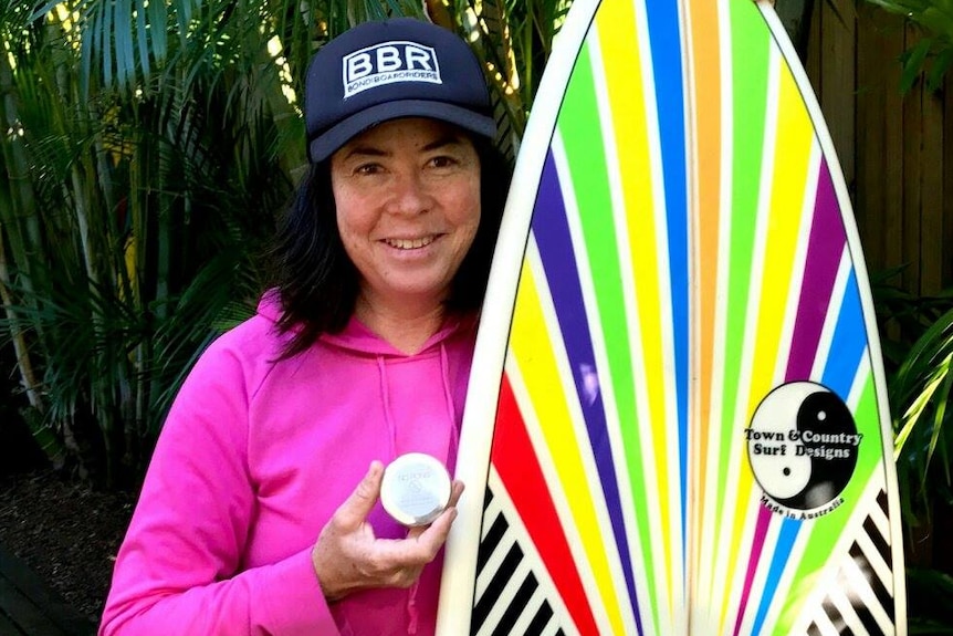 Pauline Menczer with a medal and surfboard